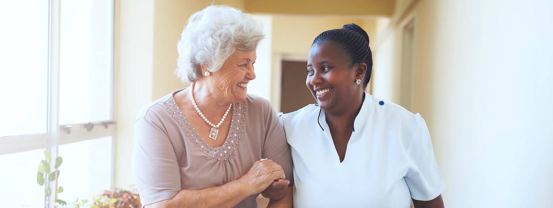 a senior and a caregiver smiling