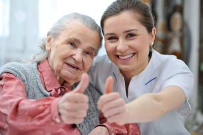 senior woman and female nurse are showing thumbs up