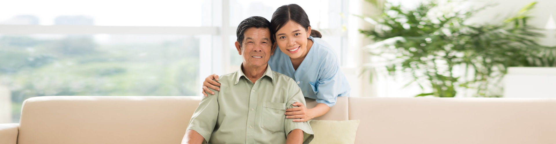 smiling caregiver hugging senior man